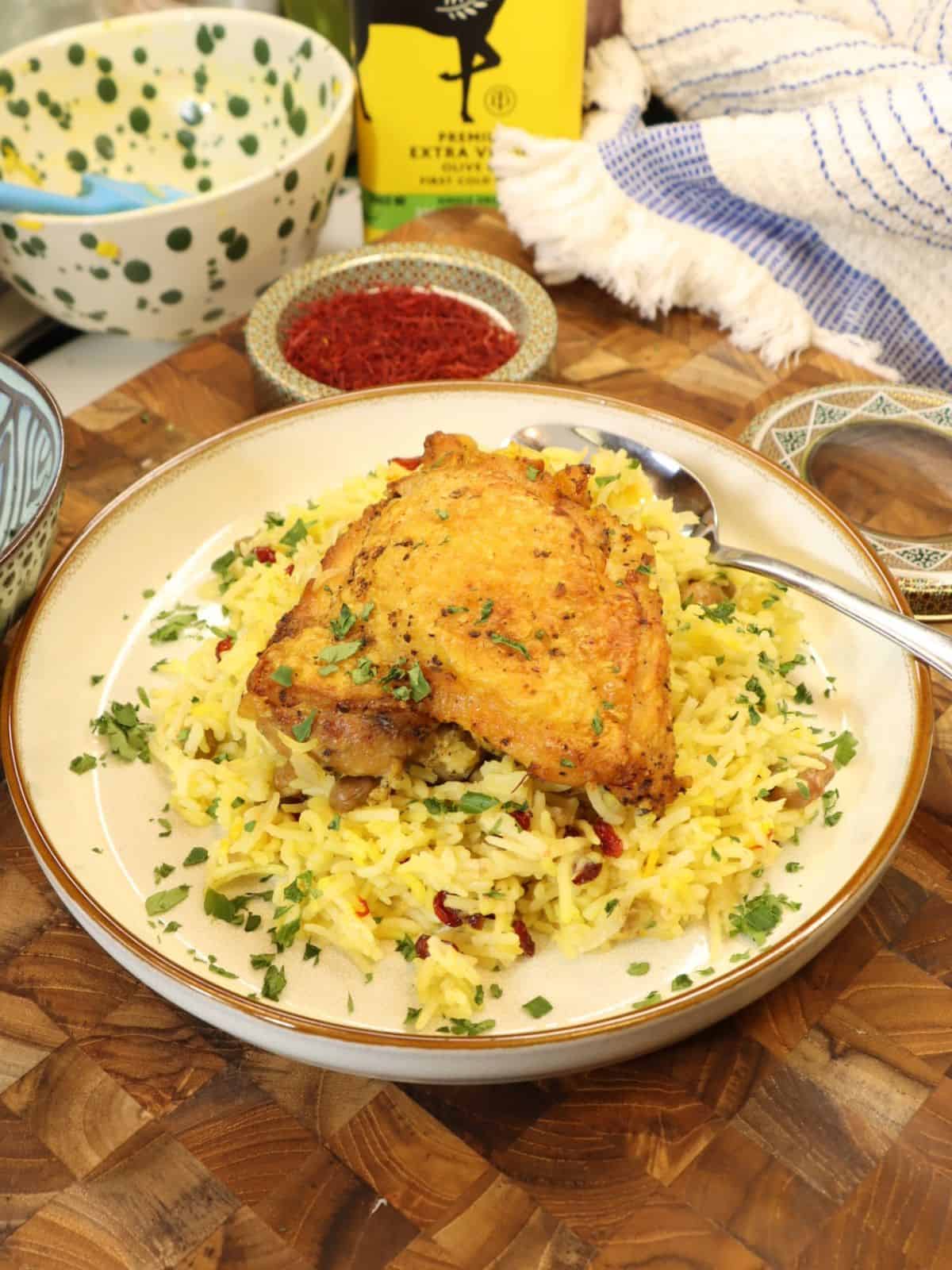 one portion on a plate of crispy saffron chicken thighs with barberries and pigeon peas
