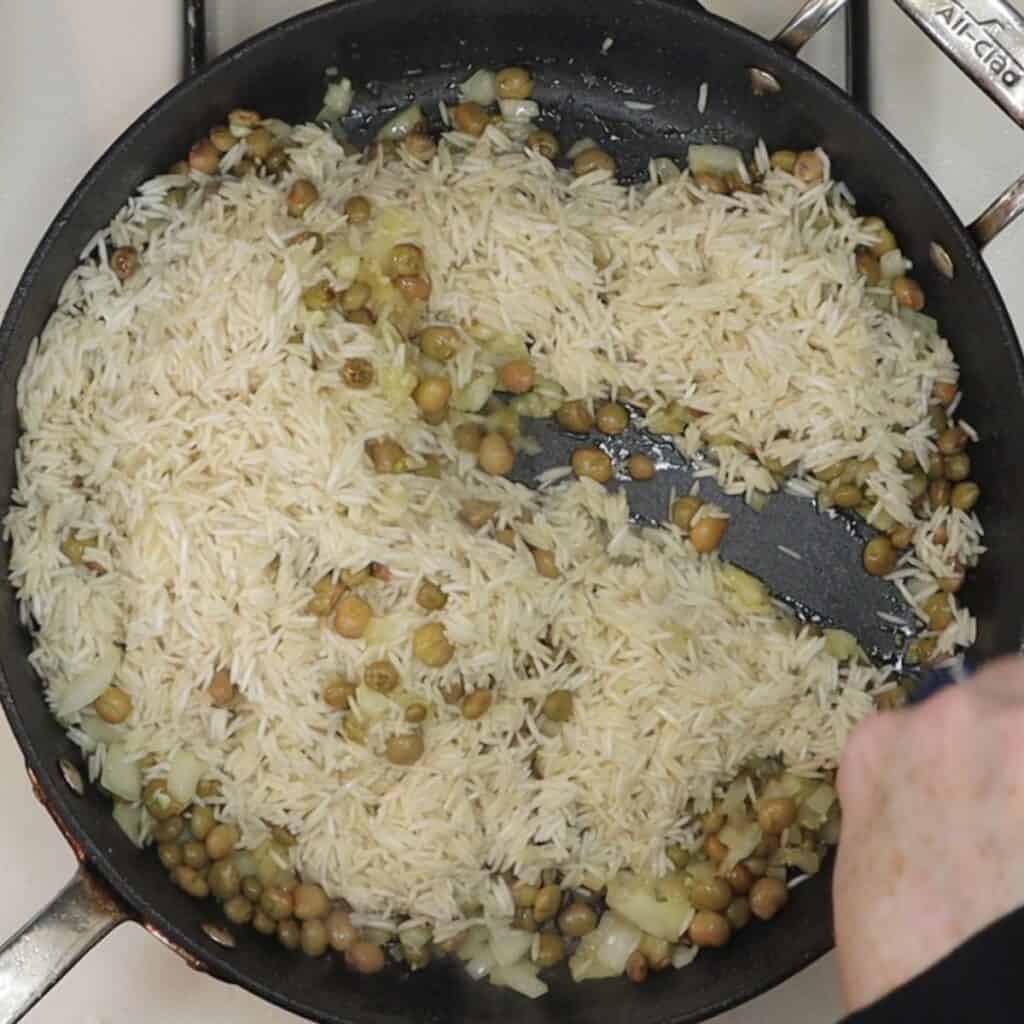 adding raw basmati rice to the pan