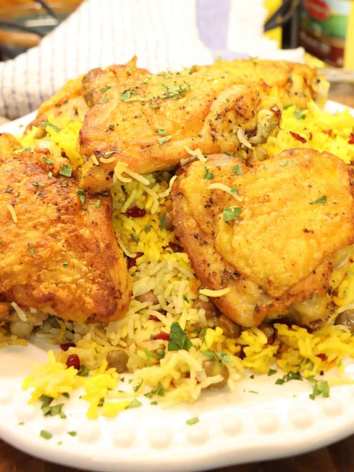 closer look at crispy saffron chicken thighs on a serving plate