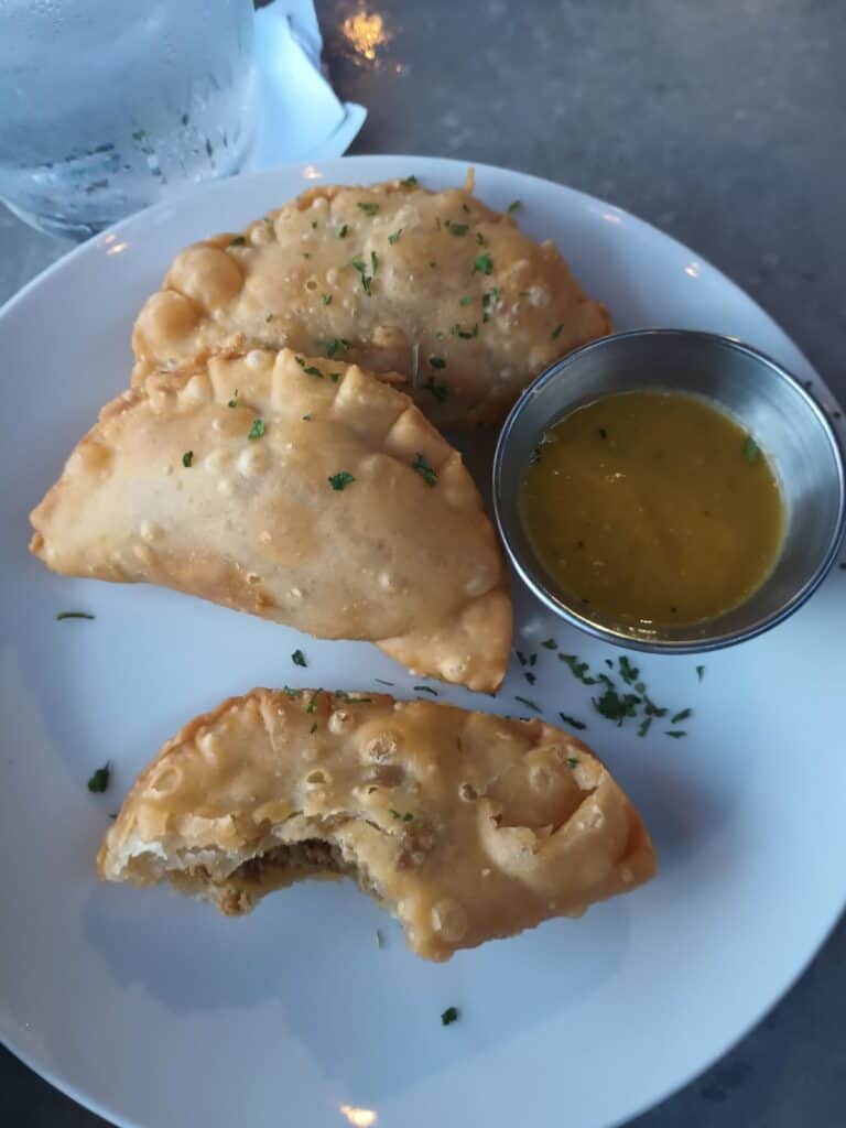 mini empanadas on a plate with bites taken