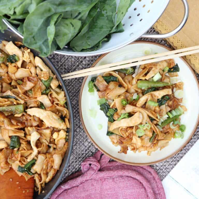 overhead view of plate and pan of Easy Chicken Pad See Ew - Stir Fry Thai Noodles