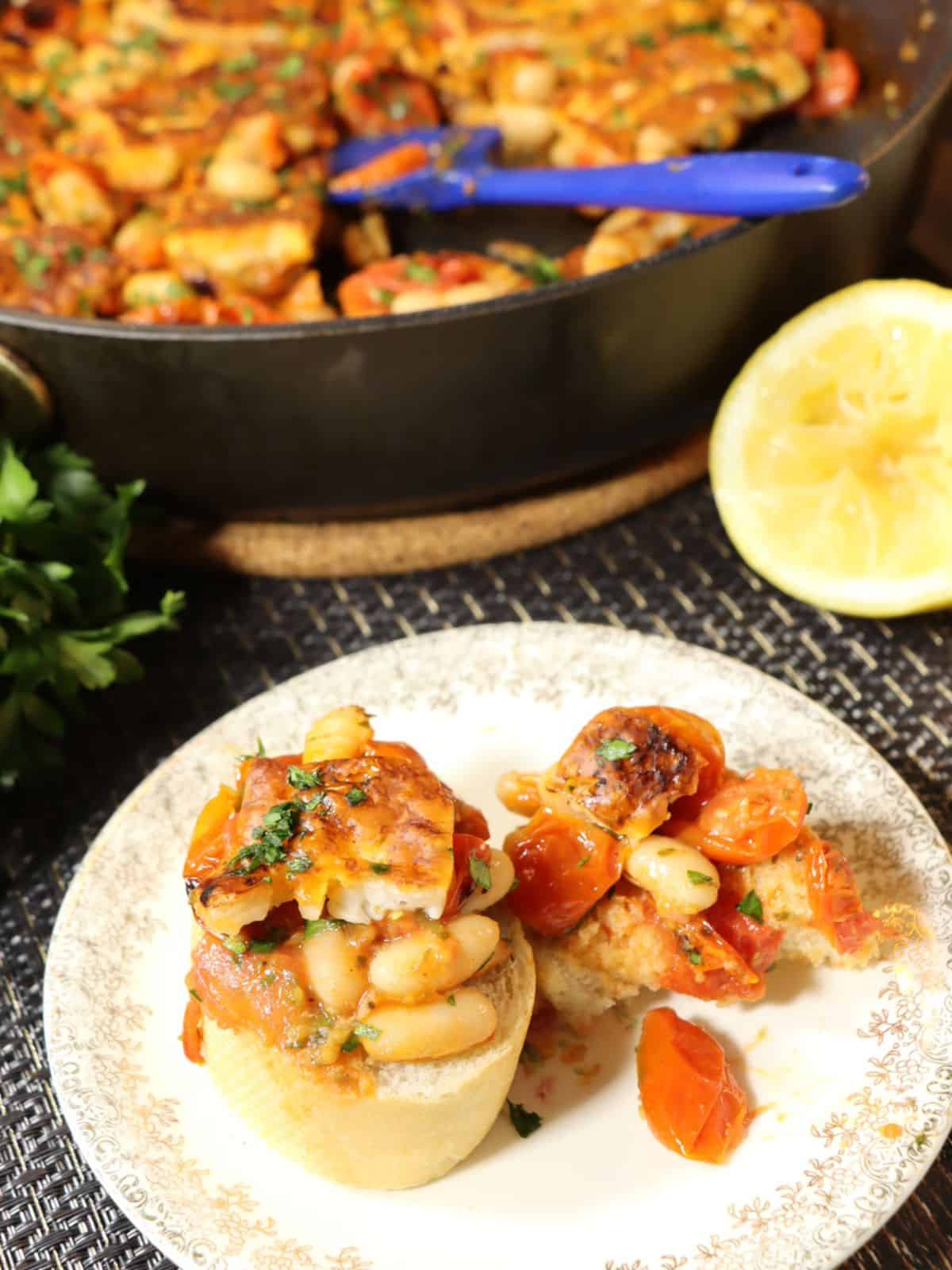 crispy halloumi with tomatoes and white beans spread on french bread with lemon in background