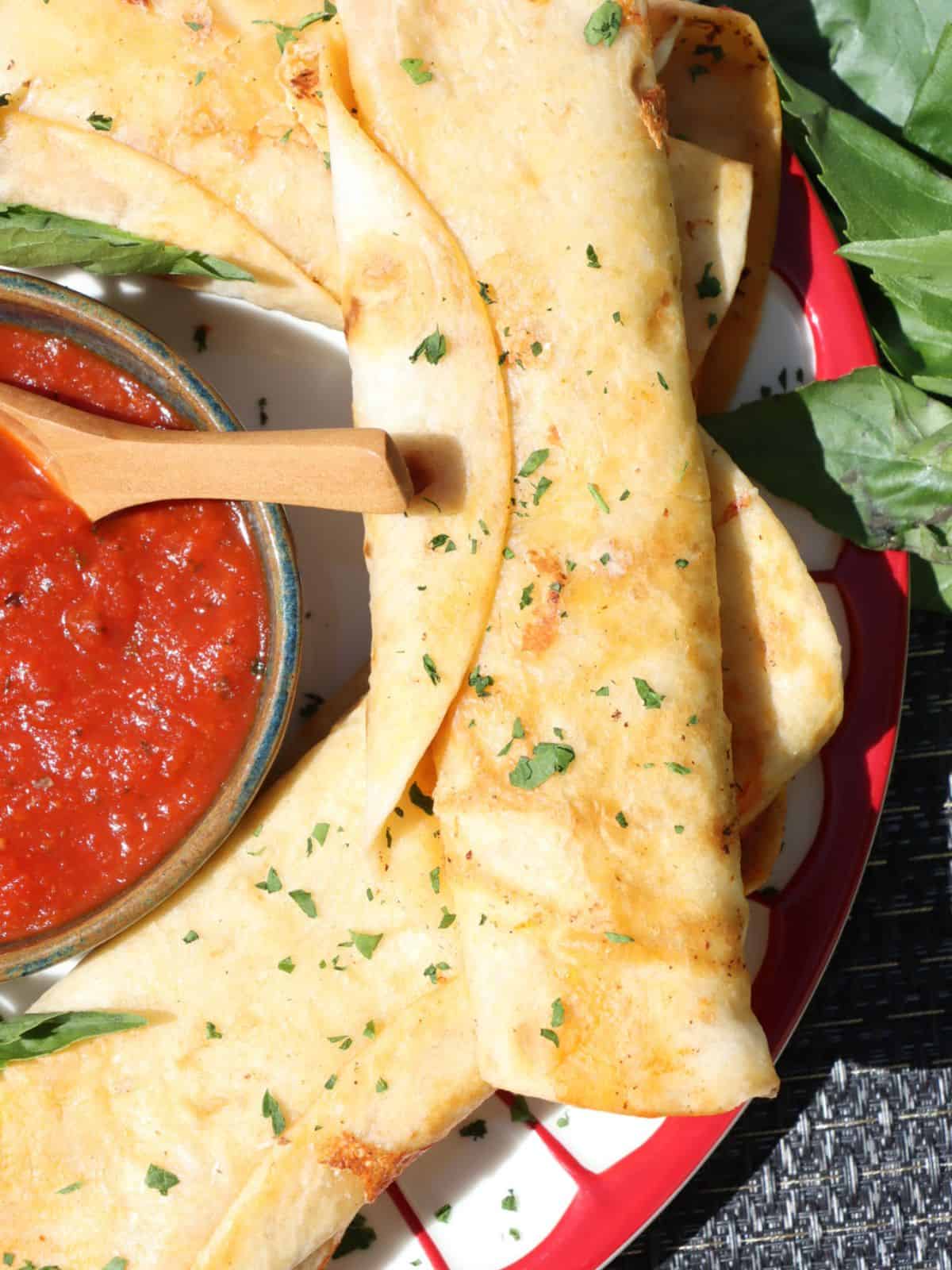 close up view of pepperoni pizza roll-ups with marinara sauce