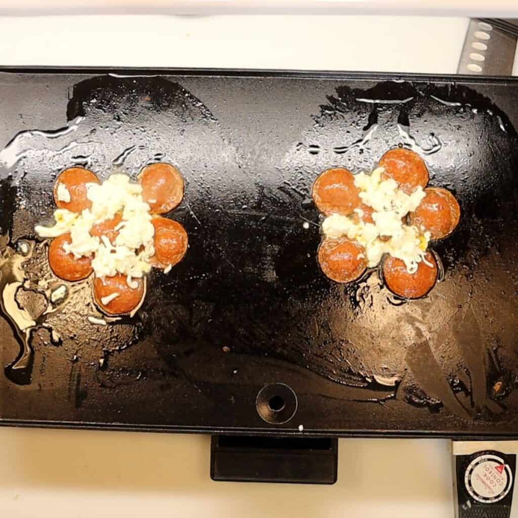 crisping pepperoni on a griddle and adding mozzarella cheese