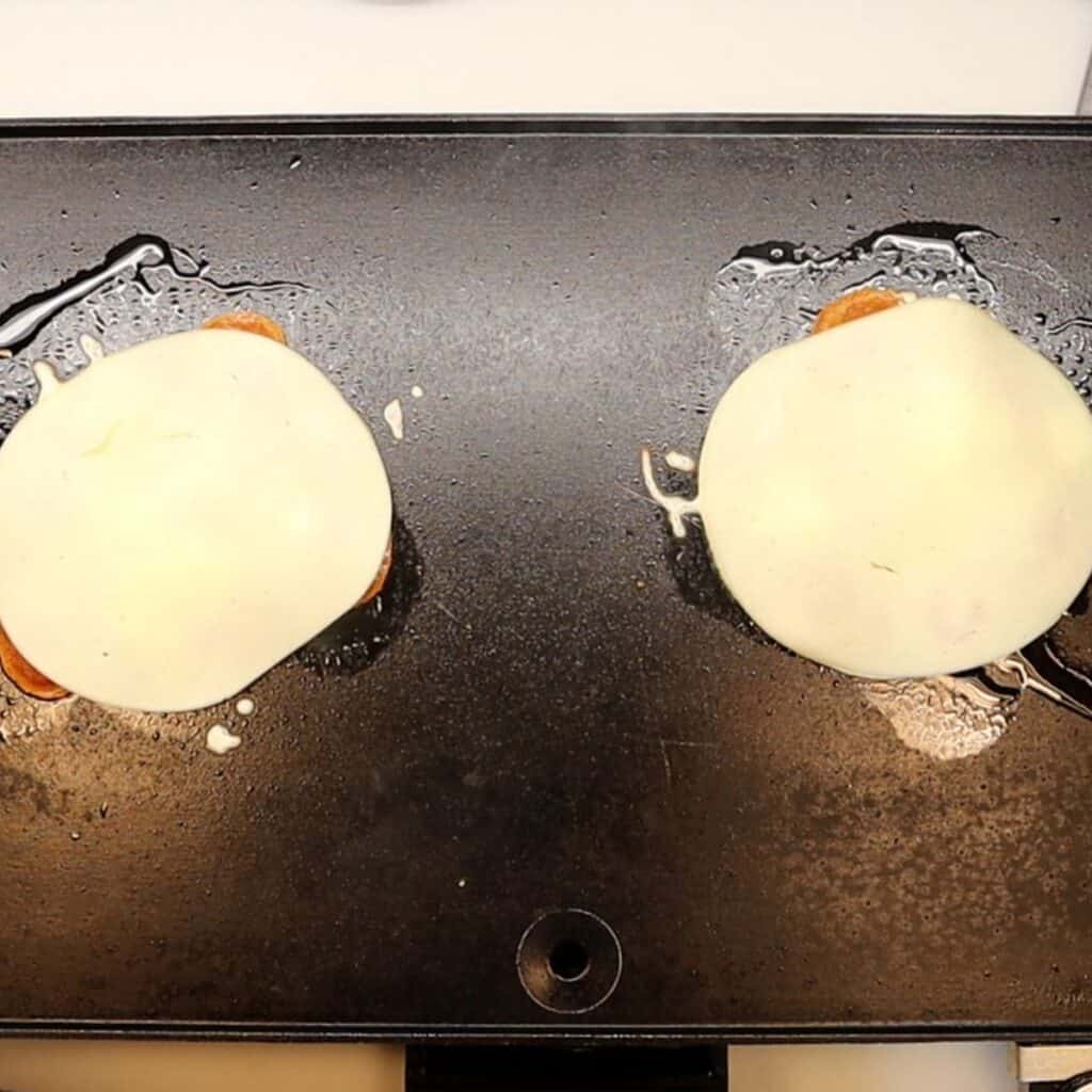 adding slices of provolone cheese on top of pepperoni and mozzarella pepperoni pizza roll-ups