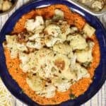 overhead view of roasted cauliflower with romesco sauce on a serving plate