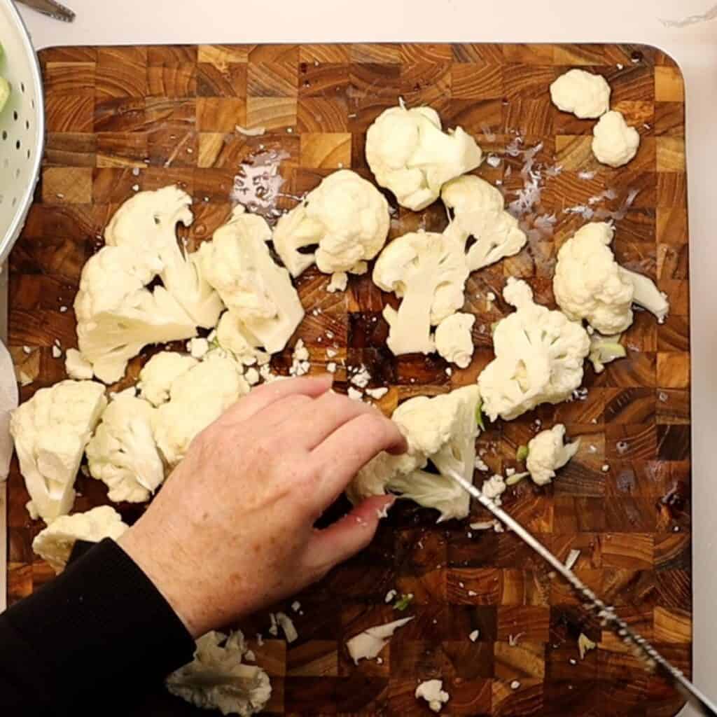 chopping cauliflower for roasted cauliflower with romesco sauce