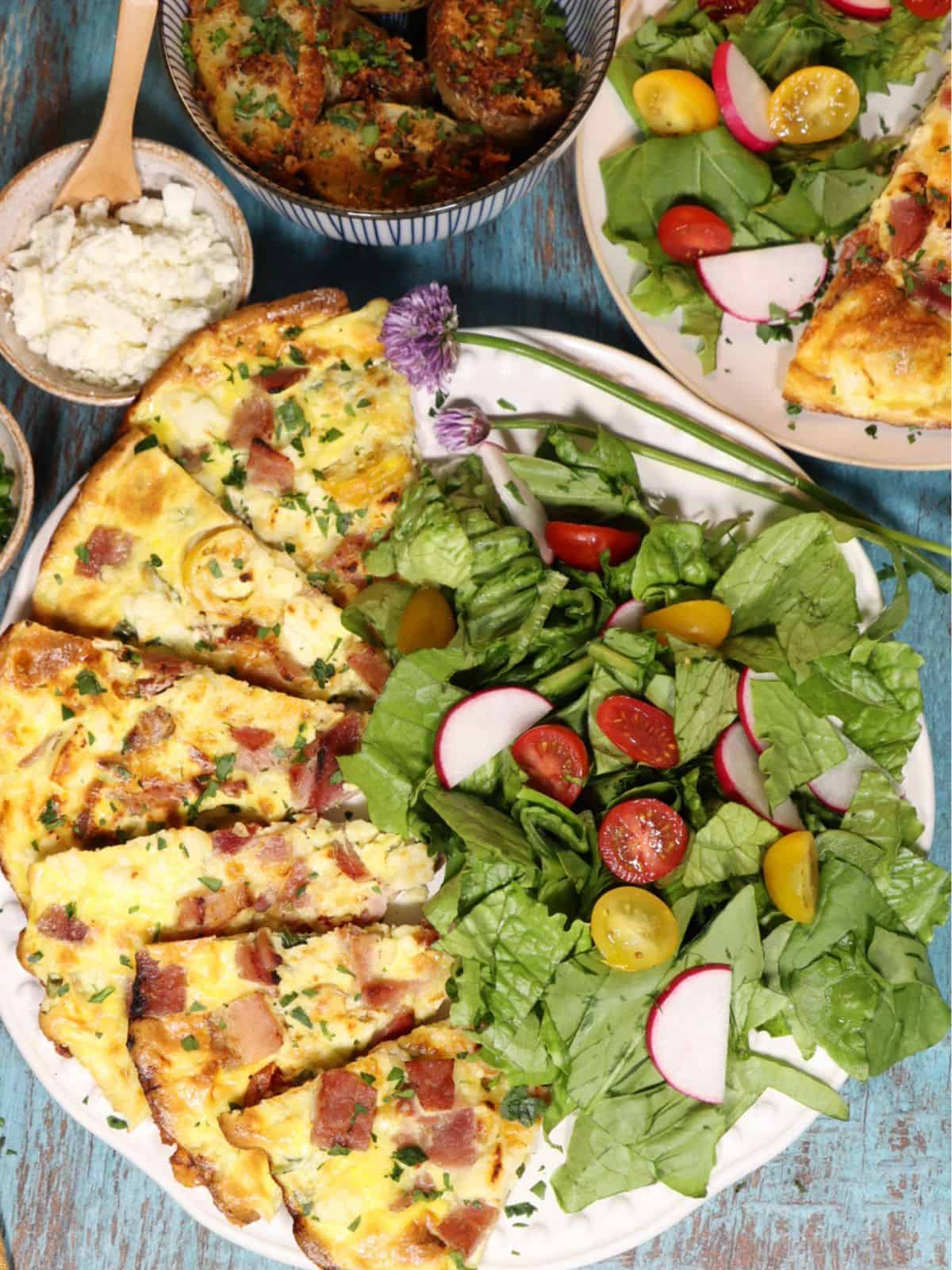 overhead view of dinner for two high protein tortilla quiche with salad potatoes and extra fixins on side